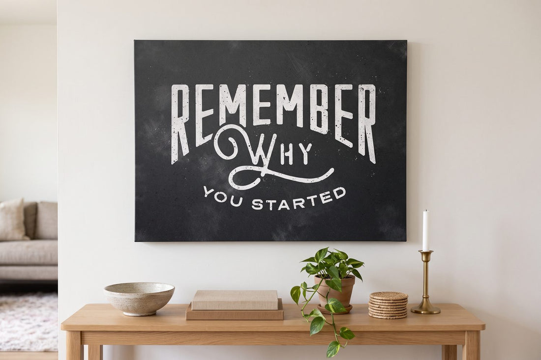 Canvas vs poster: a Remember Why You Started canvas above a light oak console with a ceramic bowl and stacked books