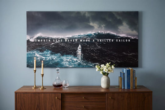 Dining room wall art: a Smooth Seas seascape canvas above a walnut sideboard with brass candlesticks in a blue dining room