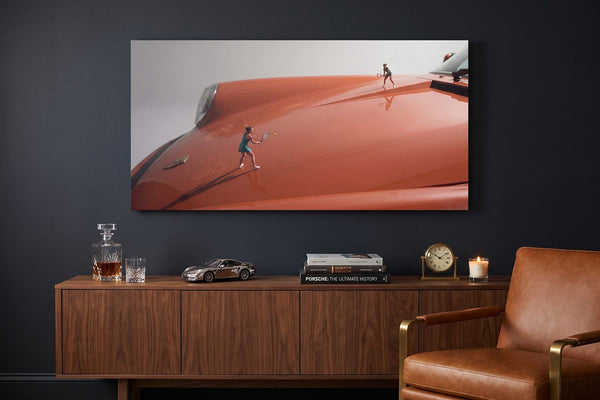 Man cave ideas: a Clay Hood car canvas on a dark lounge wall above a walnut credenza with a whisky decanter