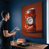 Bitter End crushed orange soda can with a white dial steel watch canvas wall art in a home interior with a person viewing it