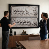Three men discussing the Boss Vs Leader marble canvas in an office meeting room