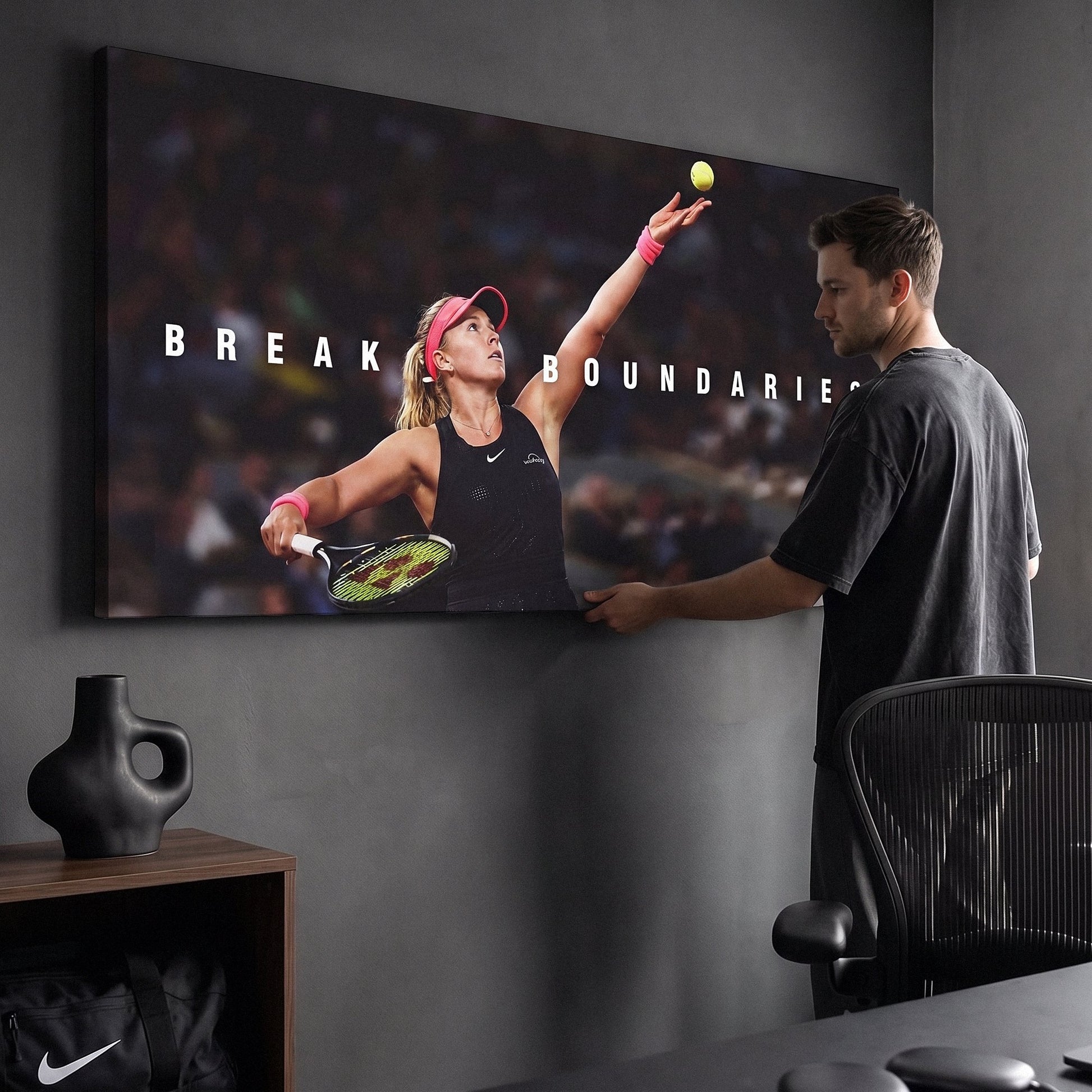 Person admiring the Break Boundaries tennis canvas print in a styled interior