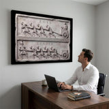 Man at his desk beneath the Boss Vs Leader Slab canvas in a modern home office