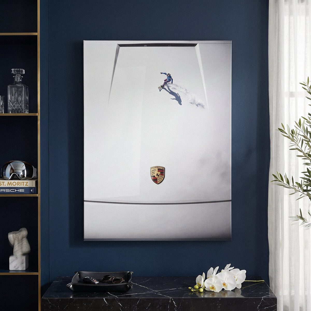 Car Boarding canvas hung on a navy wall above a black console with white orchids and a leather valet tray