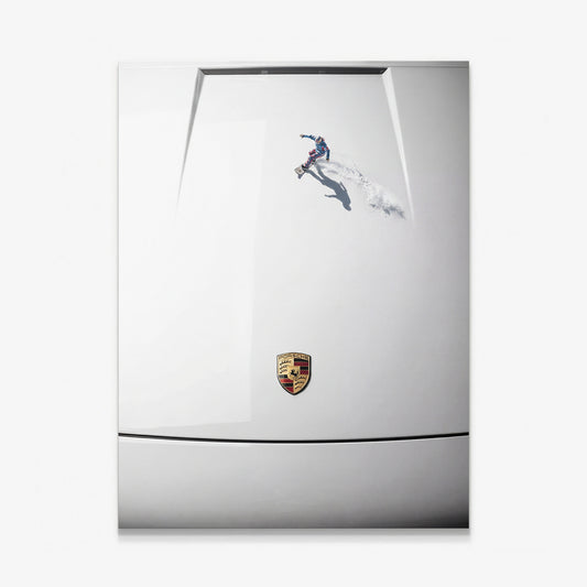 Car Boarding canvas wall art of a tiny snowboarder carving powder across a white sports car hood seen from above