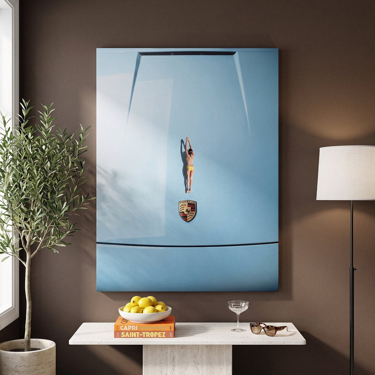 Car Dive canvas on a mocha wall above a stone console with a bowl of lemons, an olive tree and a floor lamp