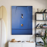 Car Surfing canvas in a surfer's room with longboards, a black shelf of fins and surf magazines, and a straw hat on a white cabinet