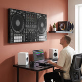 Young music producer at his desk looking up at the Don't Mix Well DJ controller canvas on a terracotta wall