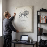 Man straightening the Endure lion quote canvas above his desk in a home office