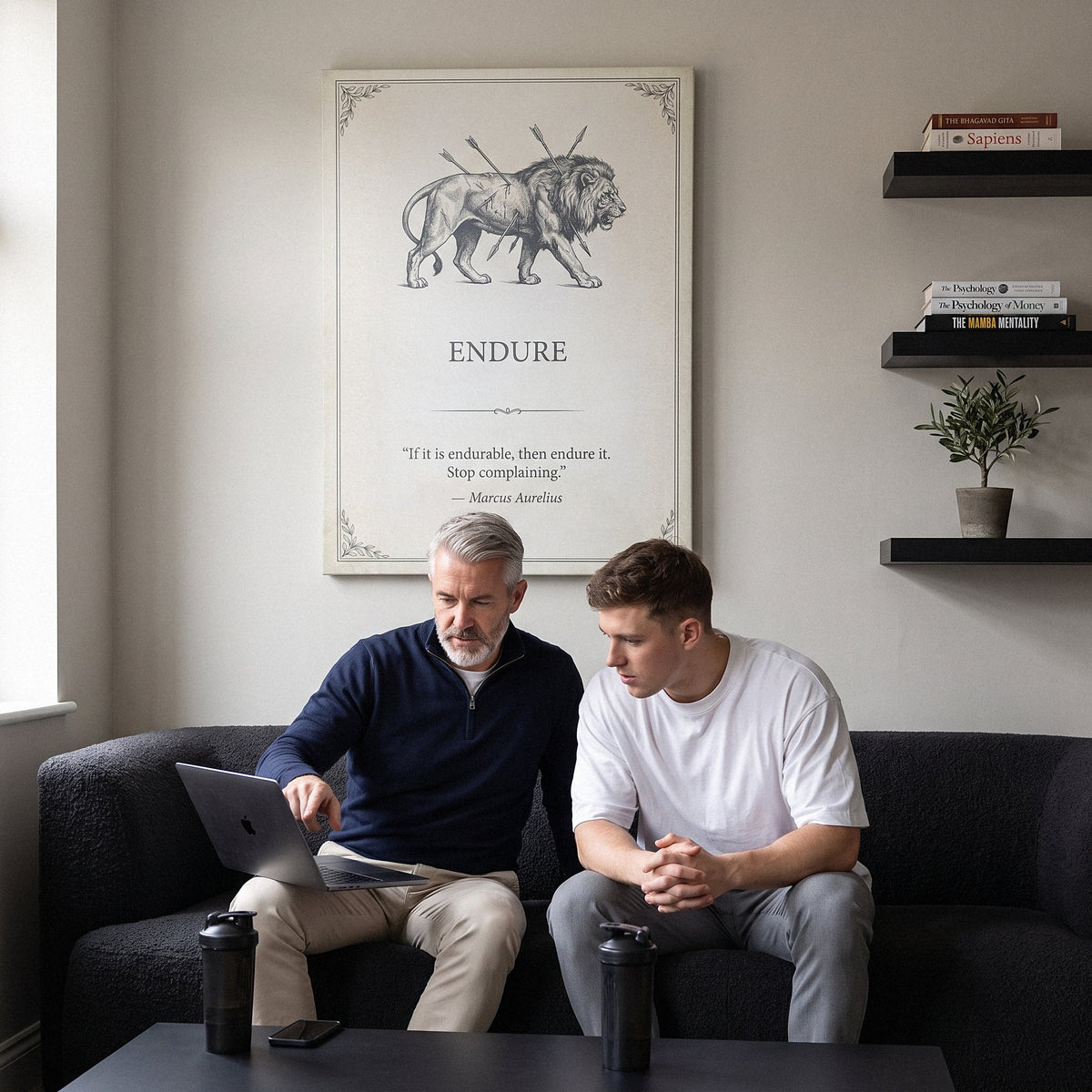Coach and athlete reviewing a training plan on a sofa below the Endure lion quote canvas