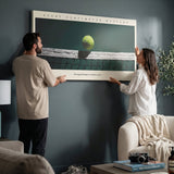 Two people holding the Every Centimeter Matters tennis panoramic canvas print in a living room