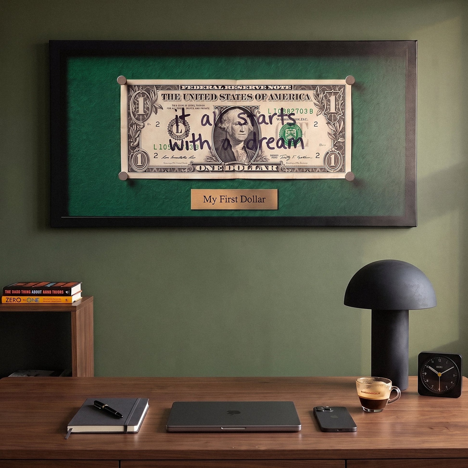 First Dollar money wall art above a walnut desk in a green home office