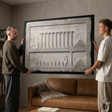 Two men hanging the Inches Apart marble canvas in a modern lounge