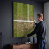 Person admiring the London Court tennis canvas print in a styled interior