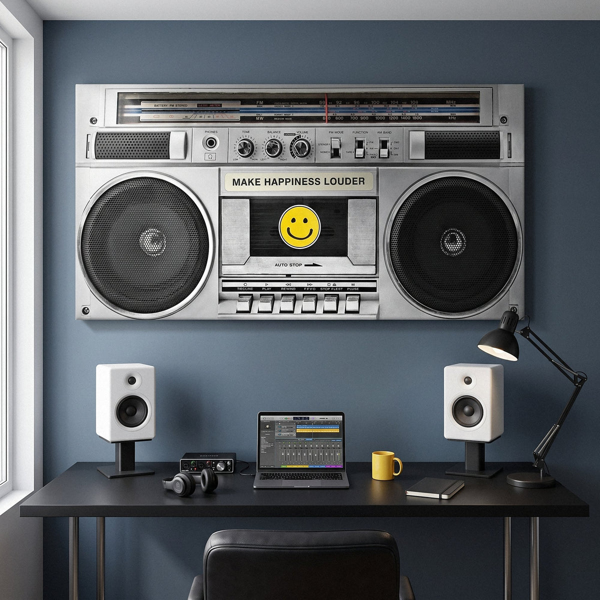 Wide Make Happiness Louder boombox canvas above a studio desk with two white monitors on a slate blue wall