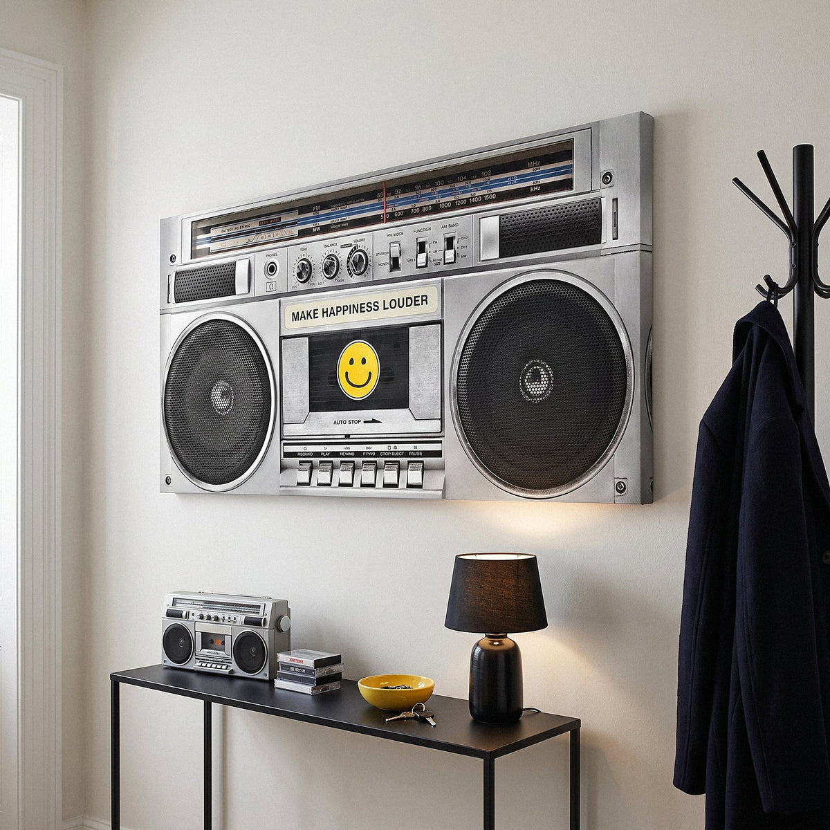 Make Happiness Louder boombox canvas above a black console in an off-white entrance hall