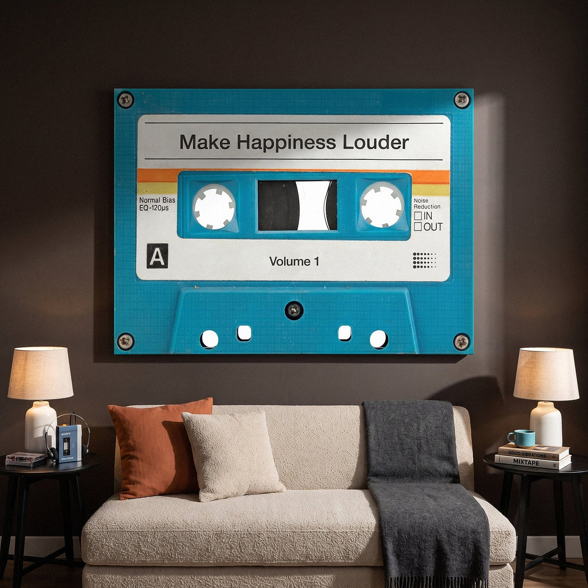 Make Happiness Louder turquoise cassette canvas above an oatmeal sofa between two table lamps on an espresso wall