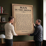 Two men holding the Man In The Arena Note Roosevelt quote canvas in a boardroom corner