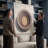 Two men hanging the Man In The Arena Colosseum canvas in a blue library