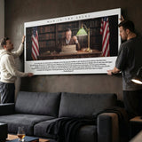 Two men hanging the Man In The Arena Roosevelt quote canvas above a sofa