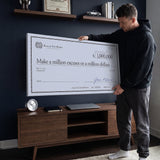 Man holding the Million Excuses Dollar Edition million dollar check canvas in a navy home office