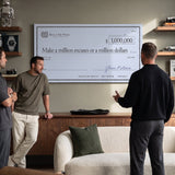 Three men viewing the Million Excuses Dollar Edition check canvas in a sage green living room