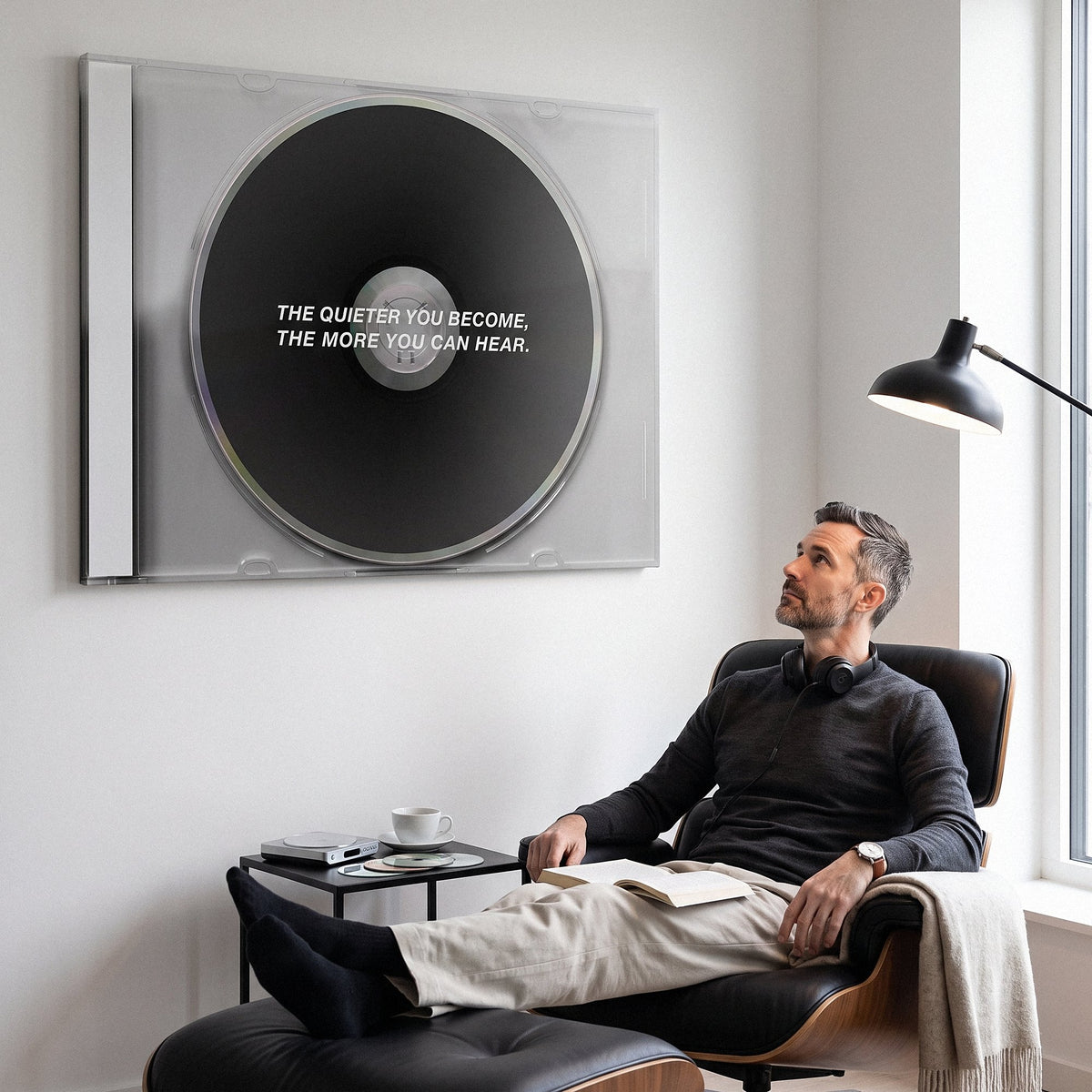 Man working at a music desk below the More You Can Hear black CD canvas