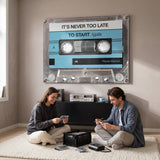 Couple relaxing in a lounge under the Never Too Late blue cassette canvas