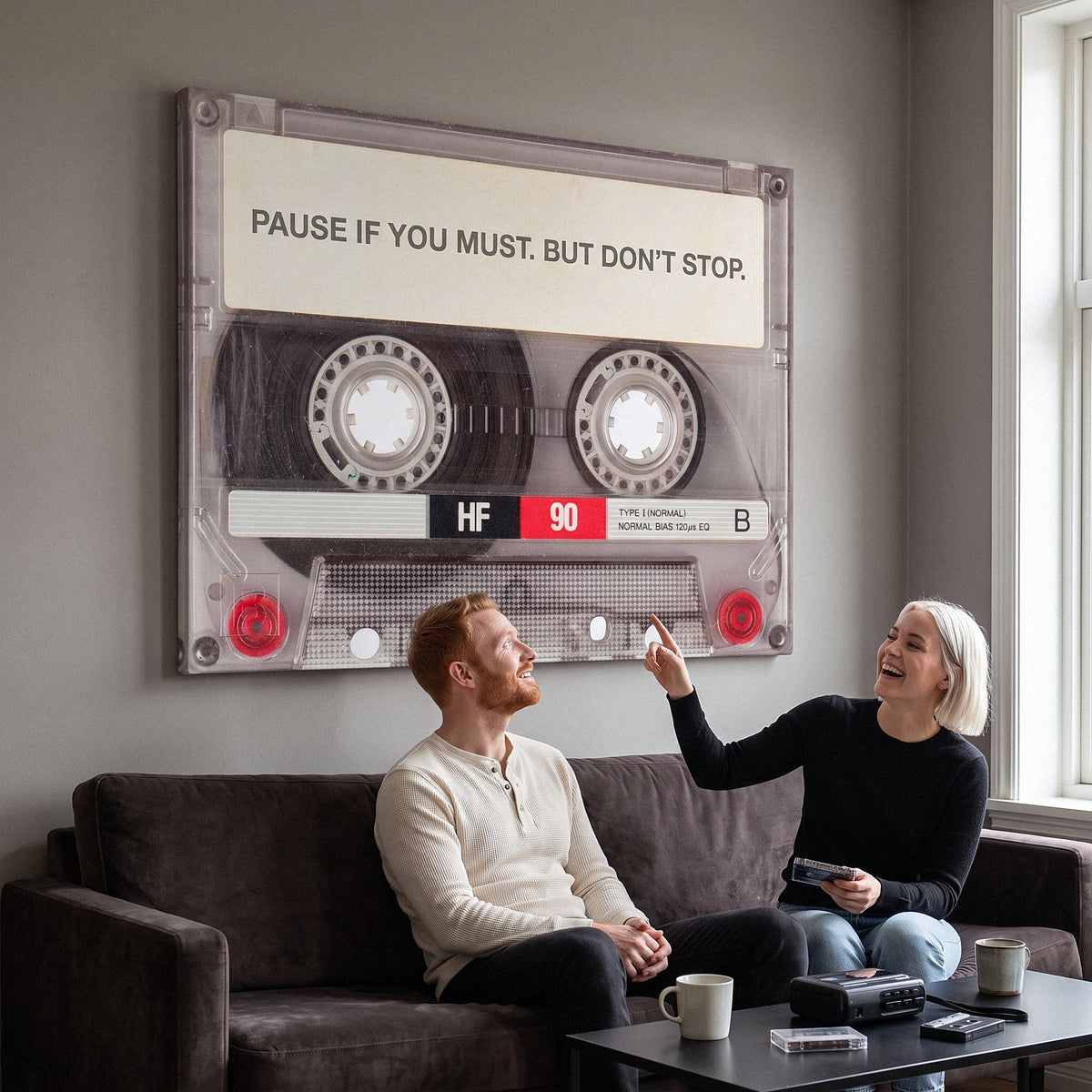 Couple relaxing in a lounge under the Pause If You Must clear cassette canvas