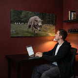 Man working at a desk beneath the Power Hides In The Shadows canvas in an oxblood den