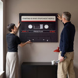 Couple relaxing in a lounge under the Press Play black cassette canvas