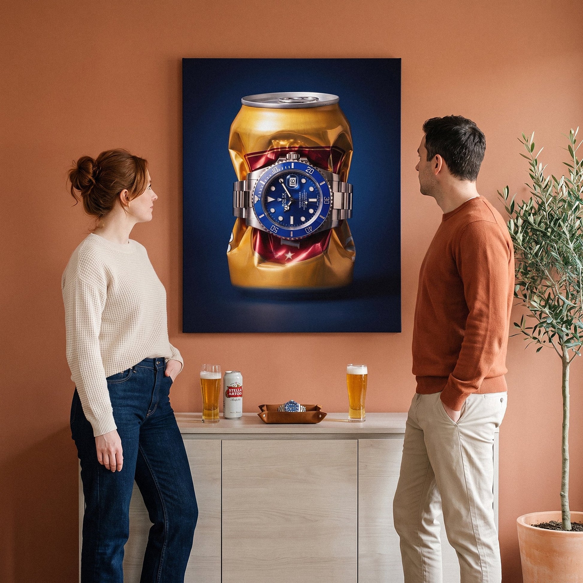 Still Ticking crushed gold can with a blue dial steel dive watch canvas wall art on a wall with two people beside it