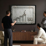 Three men admiring the Success Is Earned Not Given marble canvas in a modern office lounge
