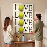 Two people holding the Tennis Love canvas print in a living room
