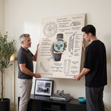 Two men holding The Azure Design chronograph blueprint canvas above a black credenza