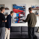 The Four coupe generation lineage canvas wall art above a living room lounge sofa