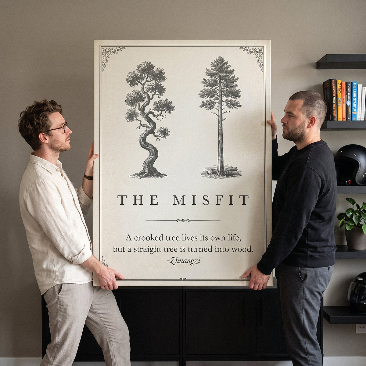 Two co-founders carrying The Misfit tree quote canvas in their office