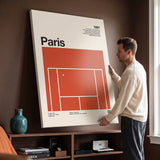 Man holding the The Paris Slam tennis canvas print against a wall