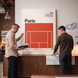 Two people holding the The Paris Slam tennis canvas print in a living room