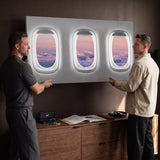 Two men hanging the Window Seat Clouds Edition airplane window clouds canvas in a home office