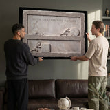 Two men hanging the Work Smarter Not Harder marble canvas in a modern lounge