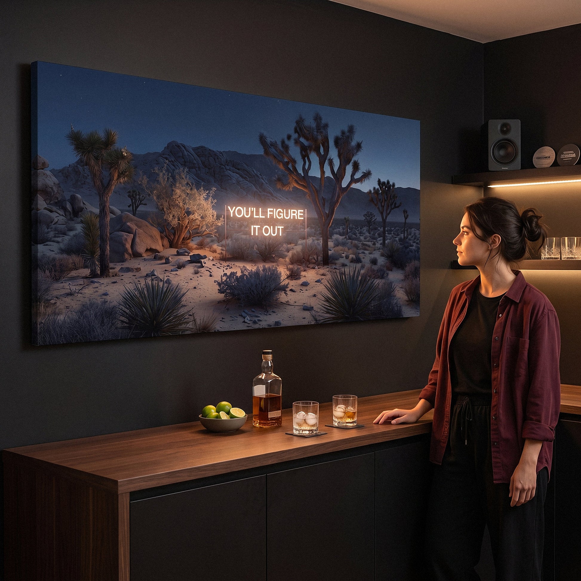 Woman at a home bar looking at the You'll Figure It Out canvas glowing on a dark wall